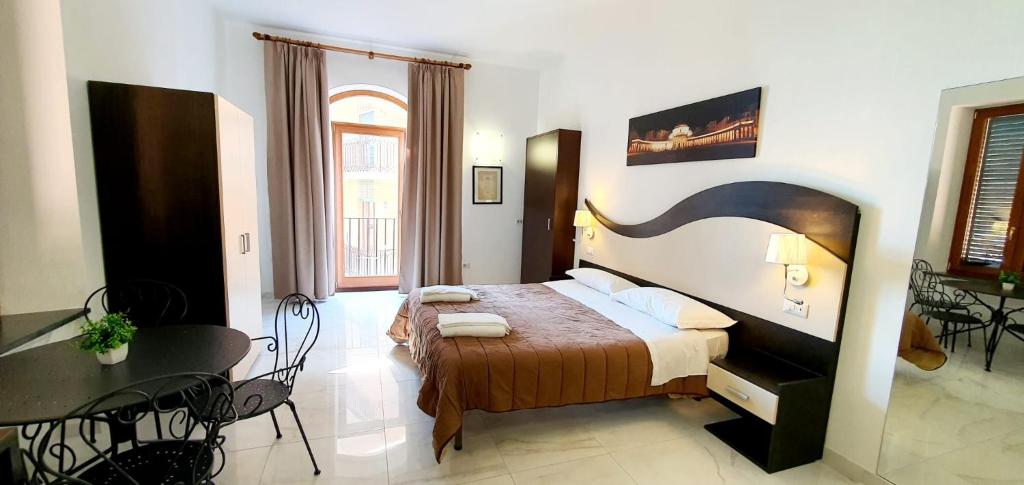 - une chambre avec un lit, une table et des chaises dans l'établissement La Maison Rose, à Maiori