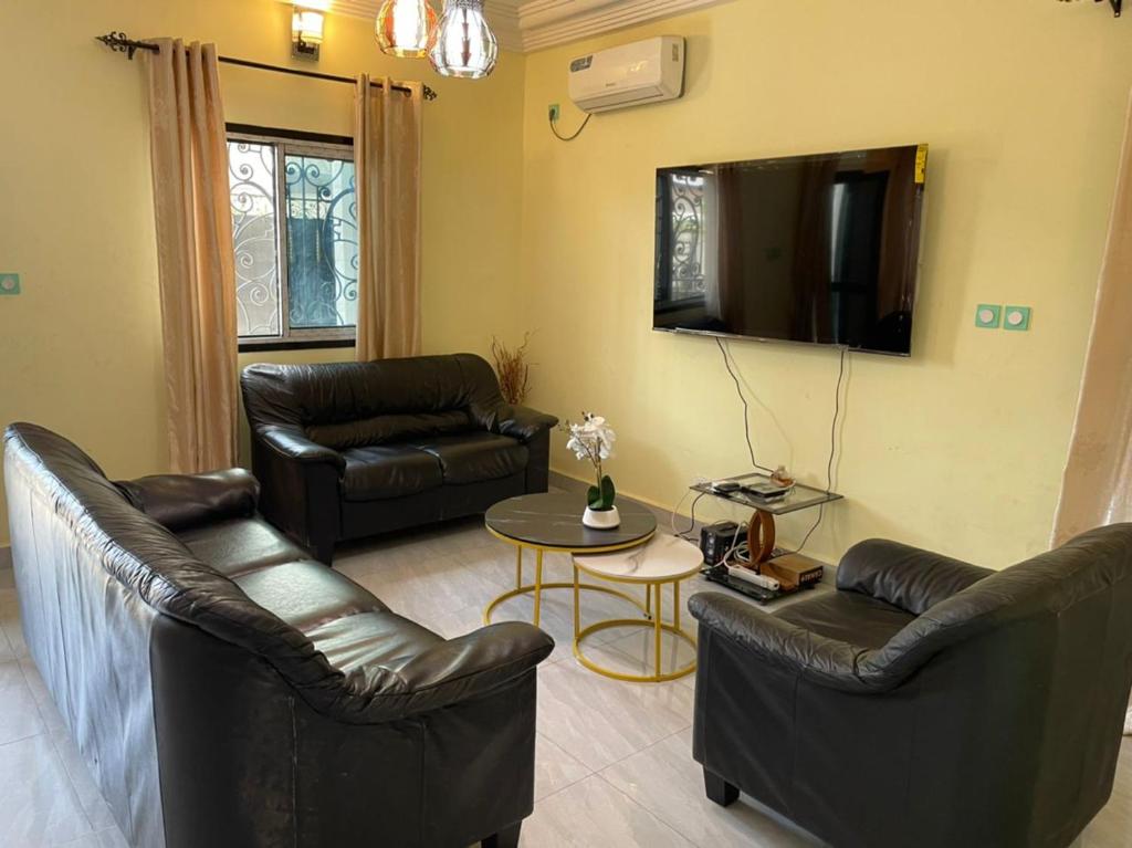 a living room with leather furniture and a flat screen tv at RESIDENCE ROYAL in Douala