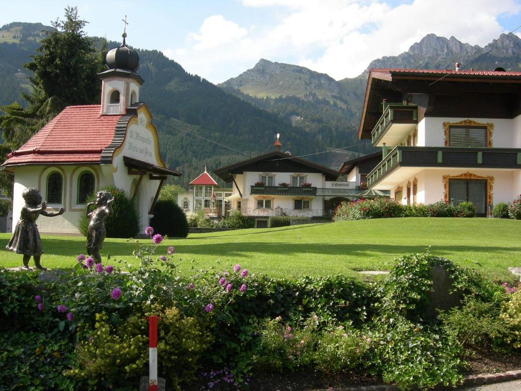 Ein paar Leute stehen vor einem Haus. in der Unterkunft S'Hoamatl in Höfen