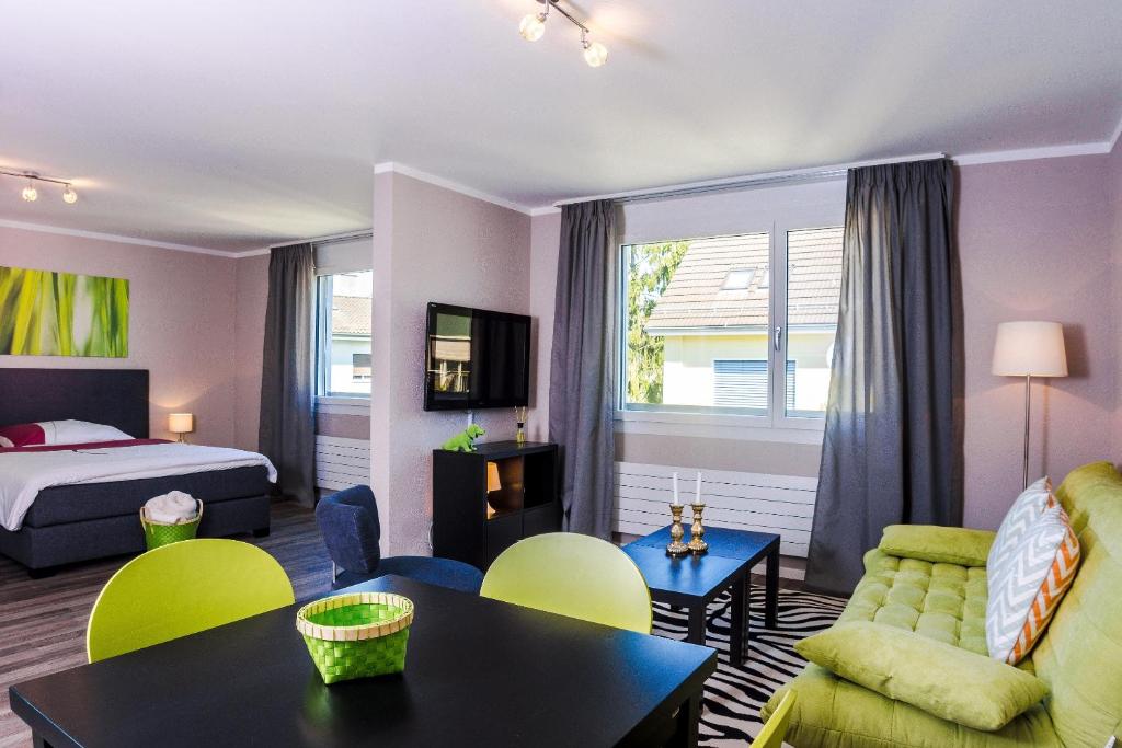 チューリッヒにあるRELOC Serviced Apartments Zurich-Oerlikonのベッドとリビングルームが備わるホテルルームです。