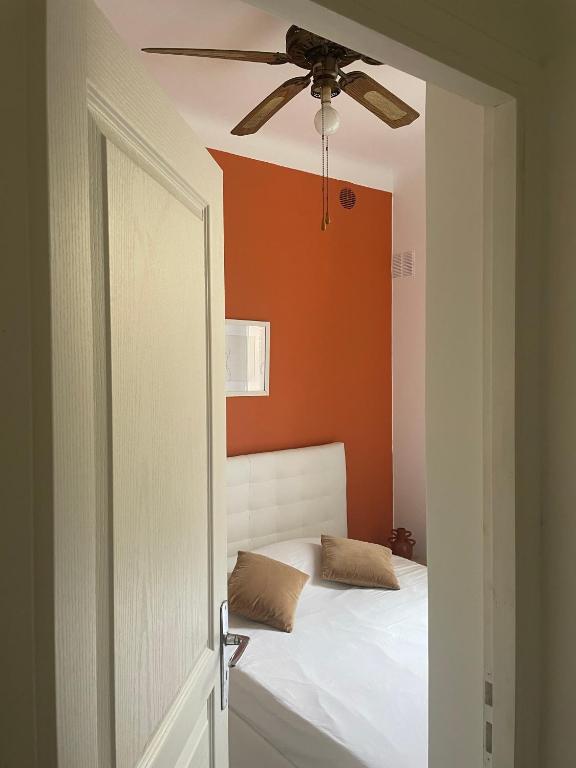 une chambre avec un lit avec un ventilateur de plafond dans l'établissement Luciana Cannes avec parking - proximité centre croisette -gare -plage, à Cannes