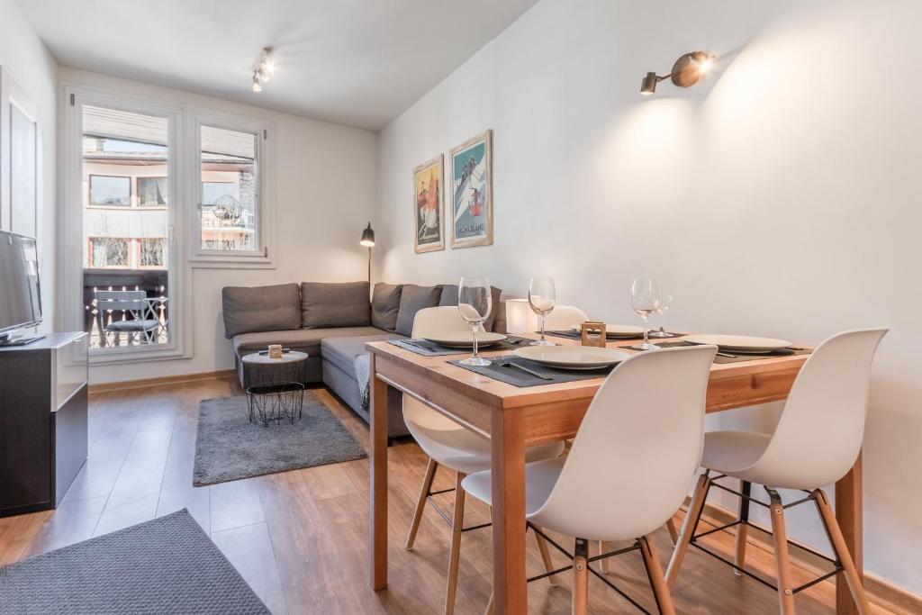 - un salon avec une table à manger et un canapé dans l'établissement Le Balcon du Brevent - Central - Vue montagne, à Chamonix-Mont-Blanc