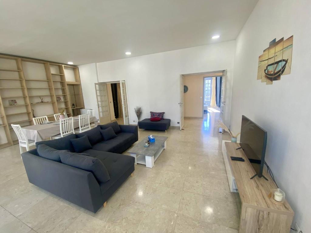 un salon avec un canapé bleu et une télévision dans l'établissement Grand F3- Centre ville de Nice, Wifi AC, à Nice