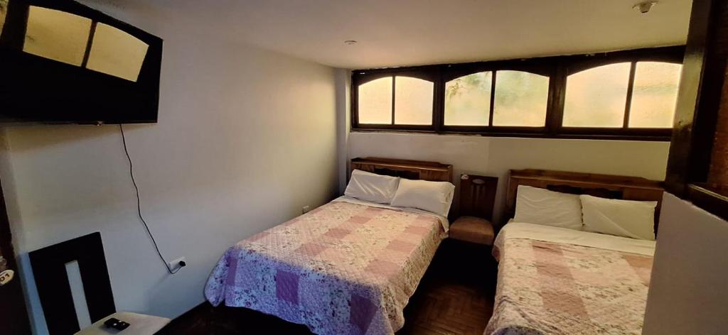 a small bedroom with two beds and a television at La casa de Mary in Cajamarca