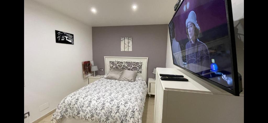 1 dormitorio con 1 cama y TV de pantalla plana en Comme à la maison, en Llanes