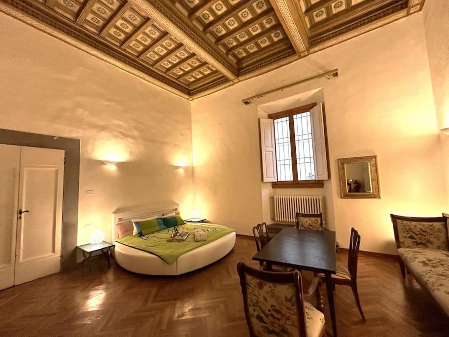 a bedroom with a bed and a table in a room at Residenza Storica in Villa Palazzo Bruciato in Florence