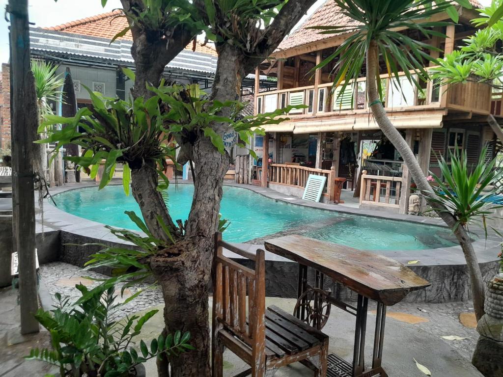 a wooden bench sitting in front of a swimming pool at Sunrise Lodge & Lounge in Singaraja