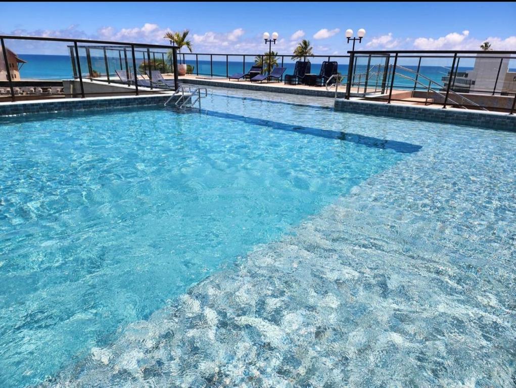 a swimming pool with blue water in a resort at Porto Atlantis -You In-80m da Praia de Porto Galinhas-PE in Porto De Galinhas
