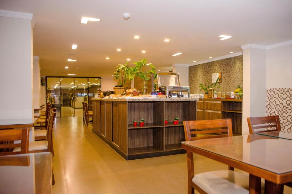 a restaurant with wooden counters and tables and chairs at Hotel Zé Maria in Pouso Alegre