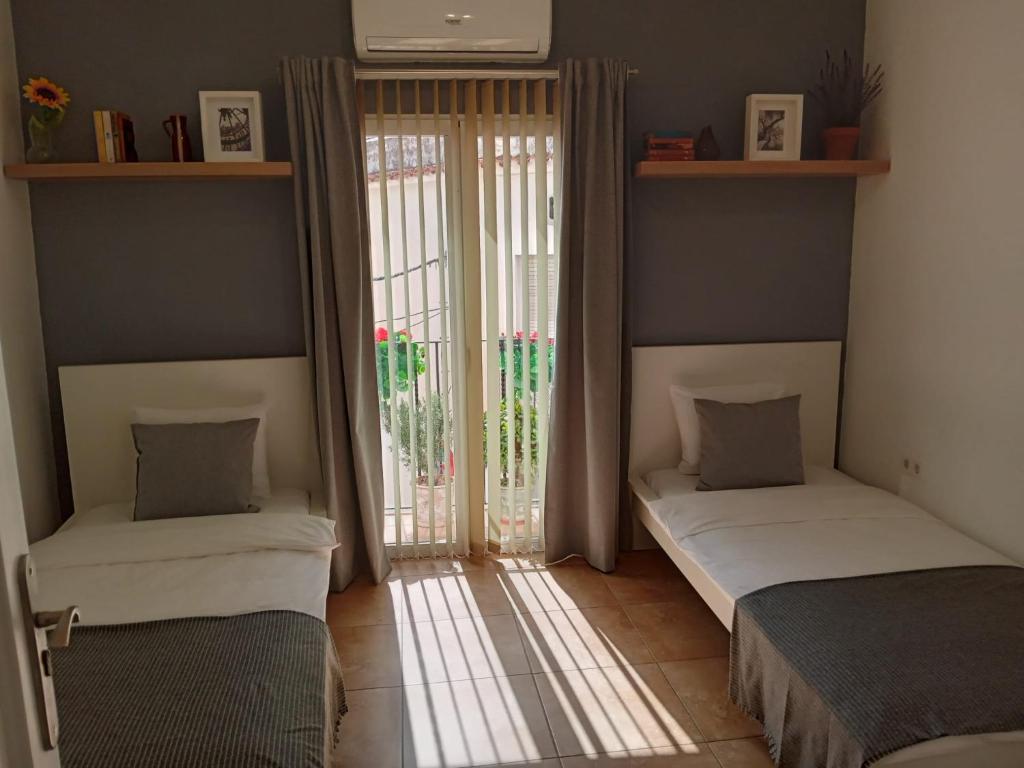 Duas camas num quarto com uma janela em Casa Elena em Orba