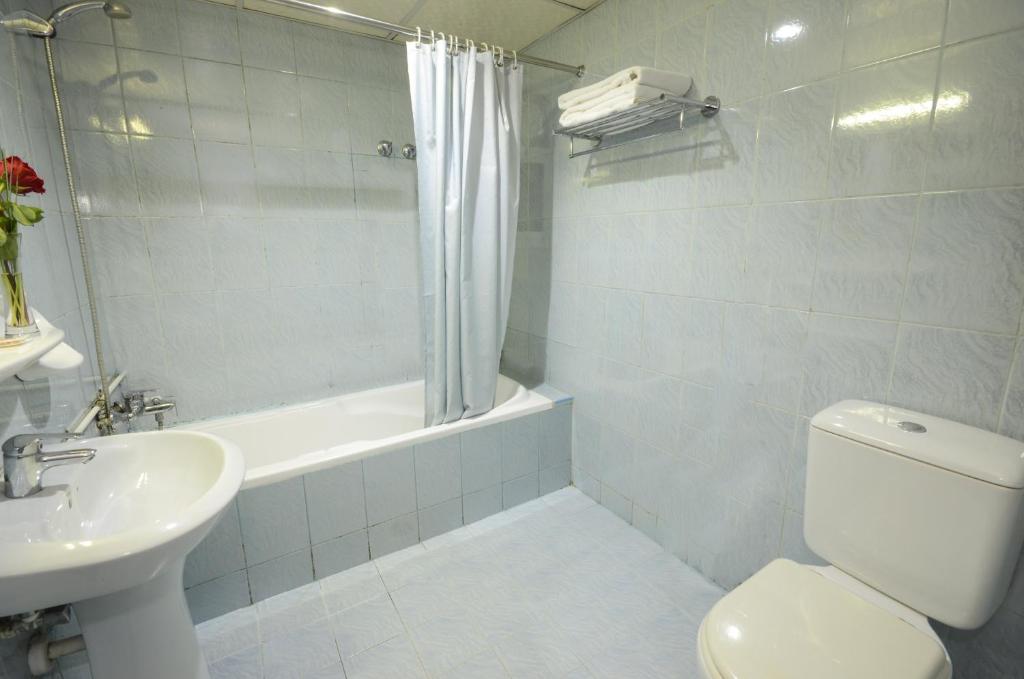a bathroom with a toilet and a sink and a shower at Royal Prince Hotel in Dubai