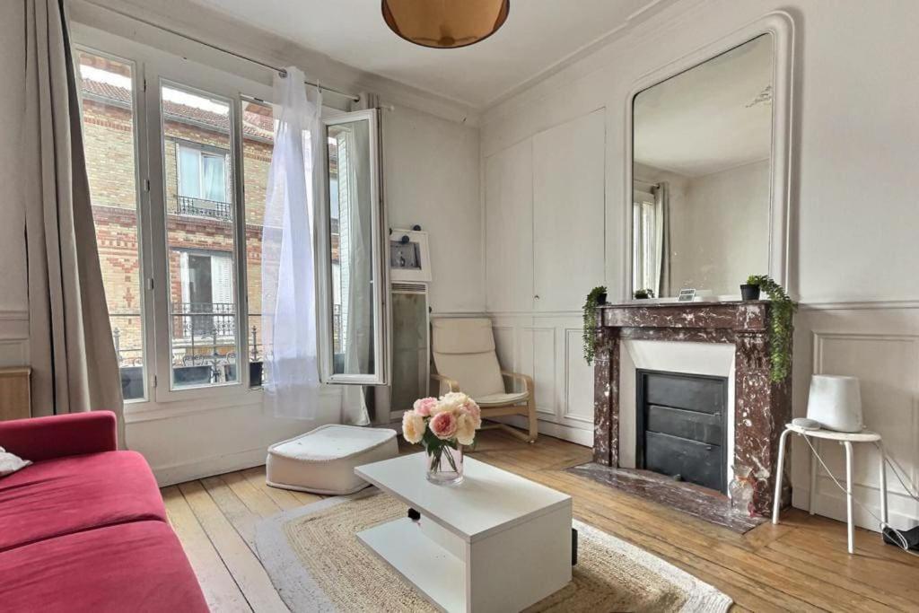 - un salon avec un canapé rouge et une cheminée dans l'établissement Boulogne 2 pièces de charme au dernier étage sur jardin., à Boulogne-Billancourt