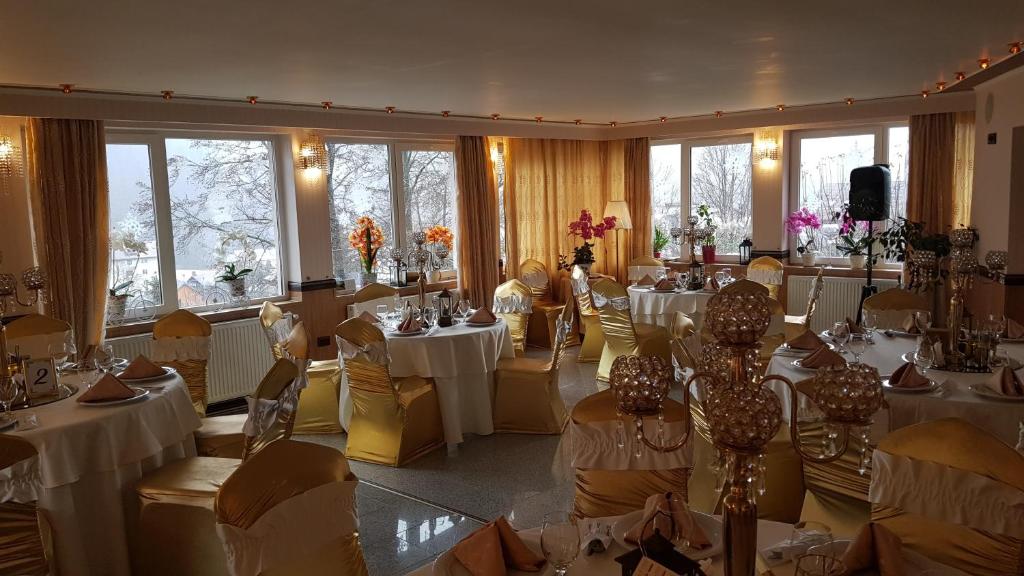 Villa Titanic Residence Spa في أَزوغا: غرفة مليئة بالطاولات والكراسي مع قماش الطاولة البيضاء