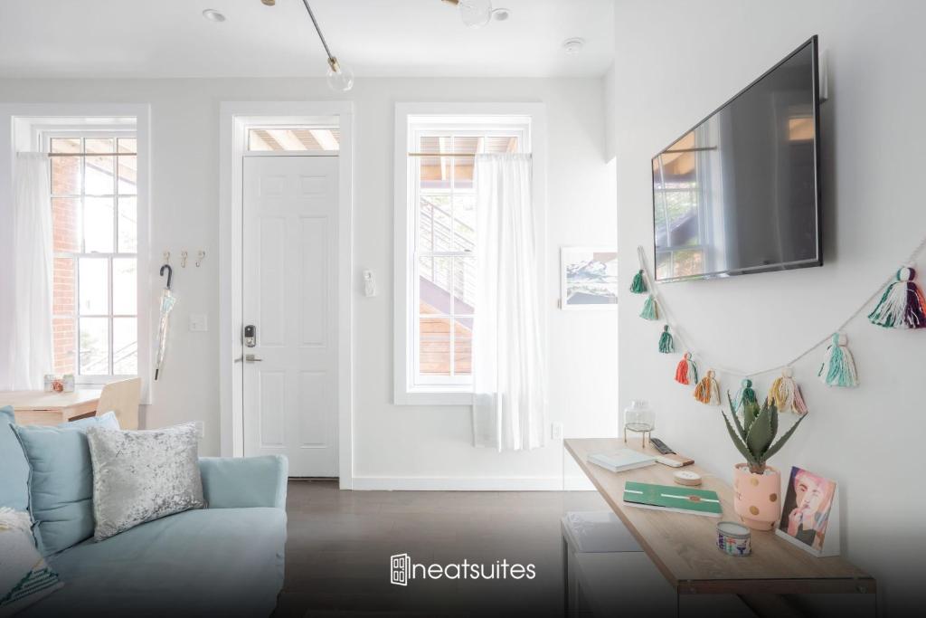 un soggiorno con divano blu e TV di Pastel Paradise - Adorable Covington Apartment a Covington