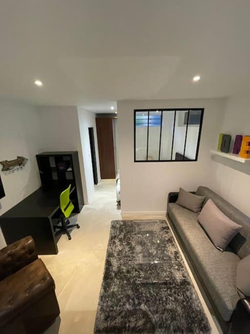 un salon avec un canapé et un bureau dans l'établissement Studio industriel loft neuf avec parking privé, à Reichstett