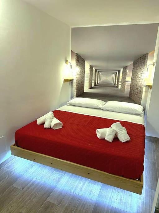 a bedroom with a large red bed with white pillows at Amore e Psiche in Scilla