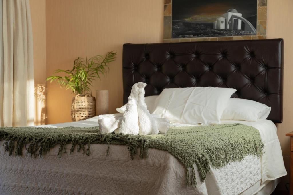 un dormitorio con una cama con dos animales de peluche en Hotel y Restaurant Doña Rode en Andacollo