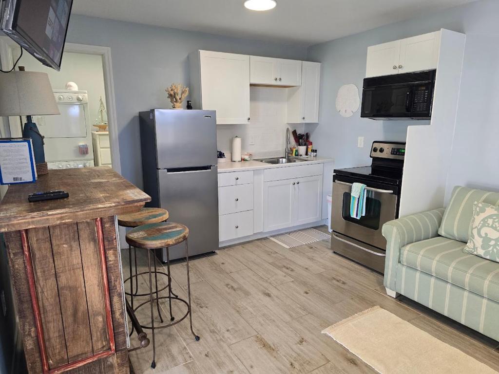 Seahorse - Tiny Home 1.2 Mi, 2 Beach Kitchen W & D Queen Bed في بونيتا سبرينغز: مطبخ مع ثلاجة ستانلس استيل وأريكة