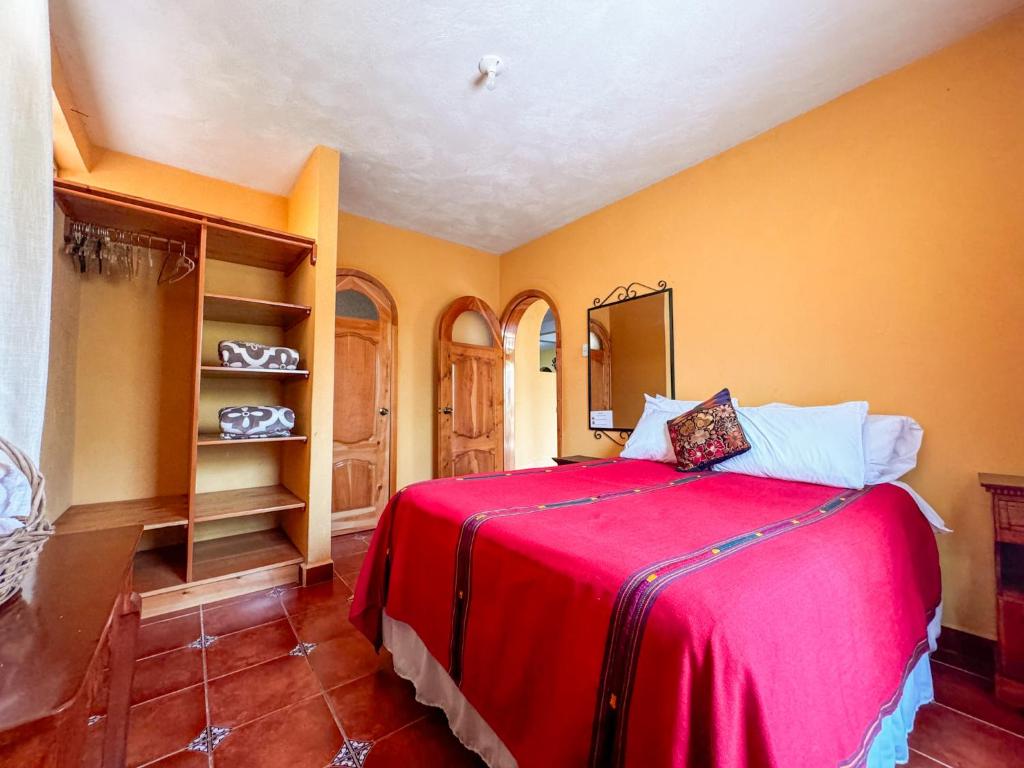 a bedroom with a bed with a red blanket at Casa Esperanza in Panajachel