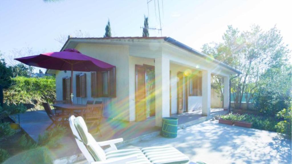 een huis met stoelen en een parasol op een patio bij Santa Petronilla - Goelba in Capoliveri