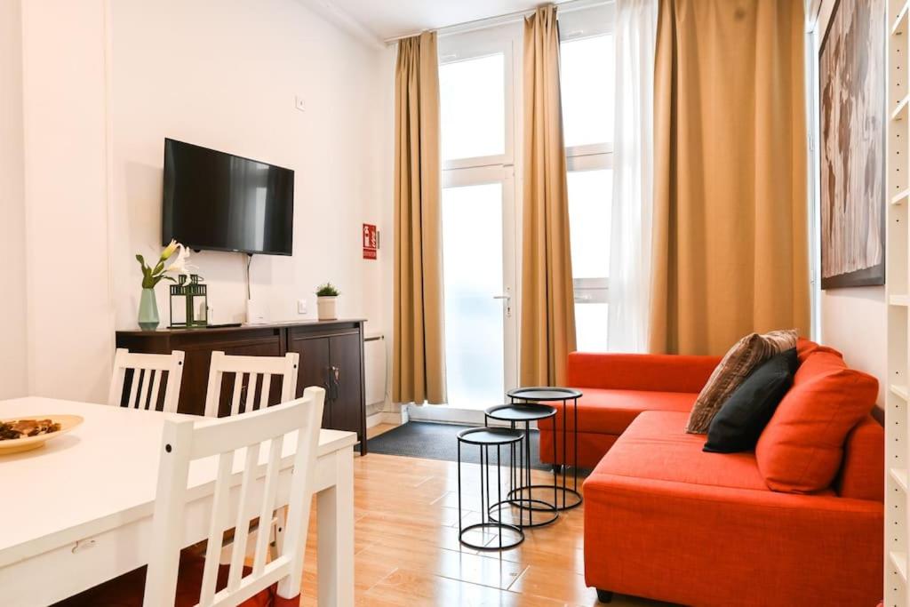 uma sala de estar com um sofá vermelho e uma mesa em For You Rentals Acogedor Apartamento de Dos Dormitorios en Madrid HDB12 em Madri