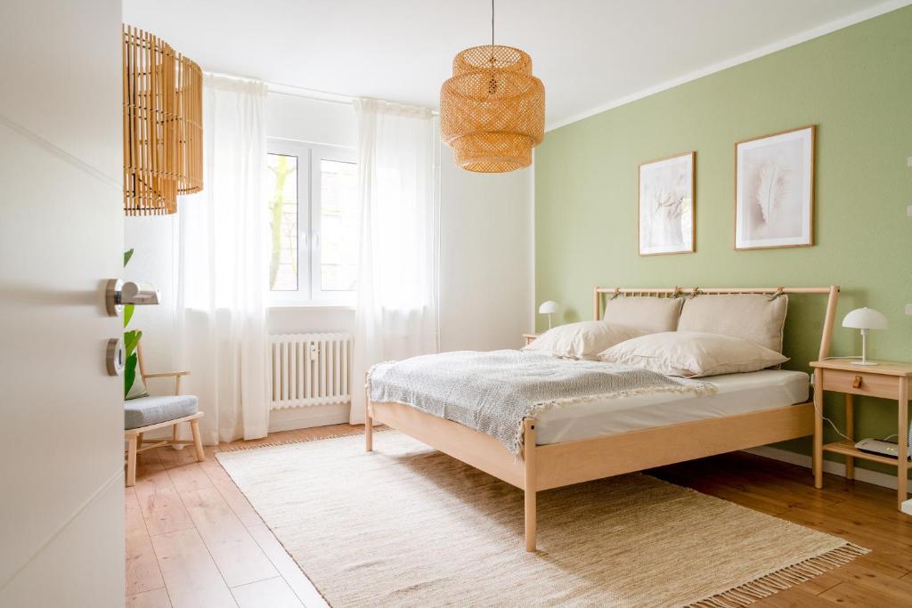 een slaapkamer met een bed en een groene muur bij Moderne Stadtwohnung im Zentrum von Bottrop! in Bottrop