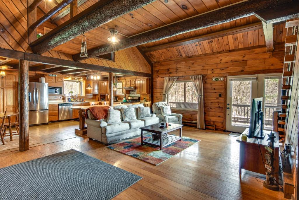 a living room with a couch and a table at Lock Haven Cabin with Wood Stove and Mountain View! in Lock Haven