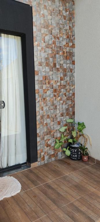 um quarto com uma parede de tijolos com uma janela e plantas em novinha, aconchegante e moderna! em Londrina