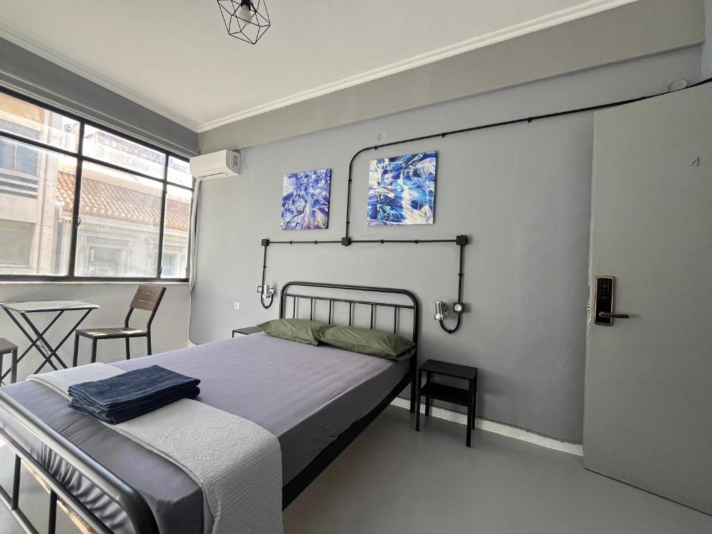 1 dormitorio con 1 cama, mesa y sillas en Urban Rooms, en Atenas
