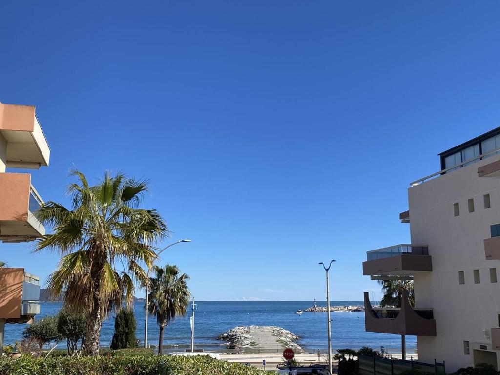 une vue sur l'océan depuis un immeuble dans l'établissement Studio climatisé avec jardin en front de mer, proche commerces, garage fermé - FR-1-100-334, à Cavalaire-sur-Mer