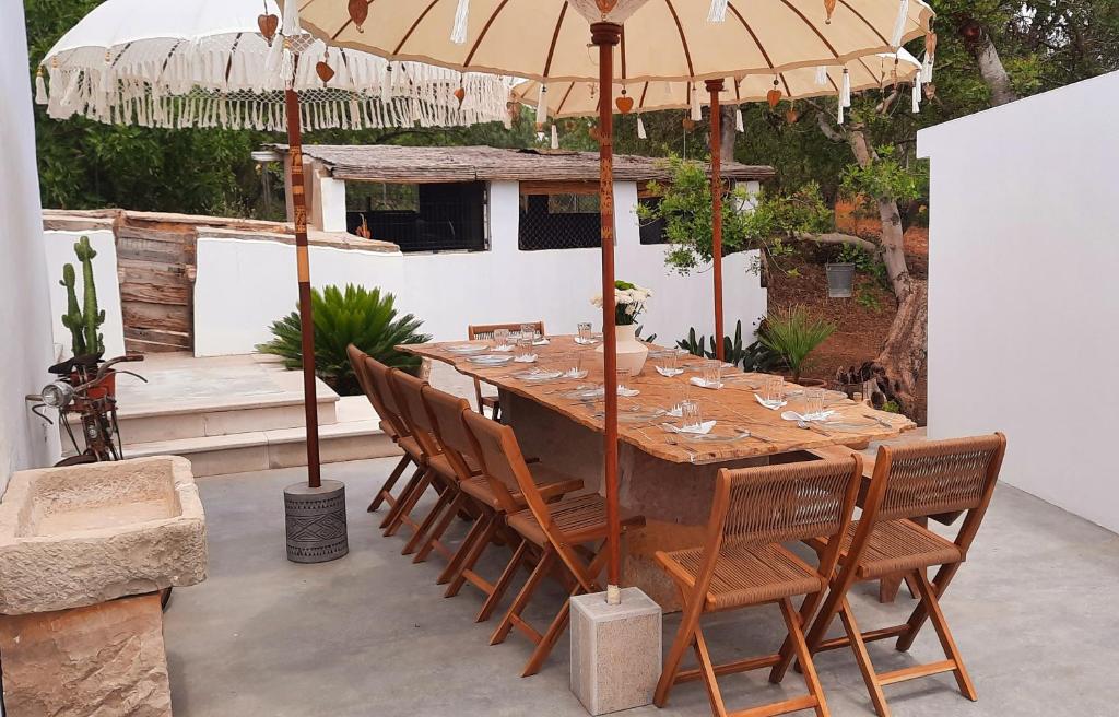 una mesa y sillas bajo una sombrilla en un patio en Quinta das Pedras - Tavira, en Tavira