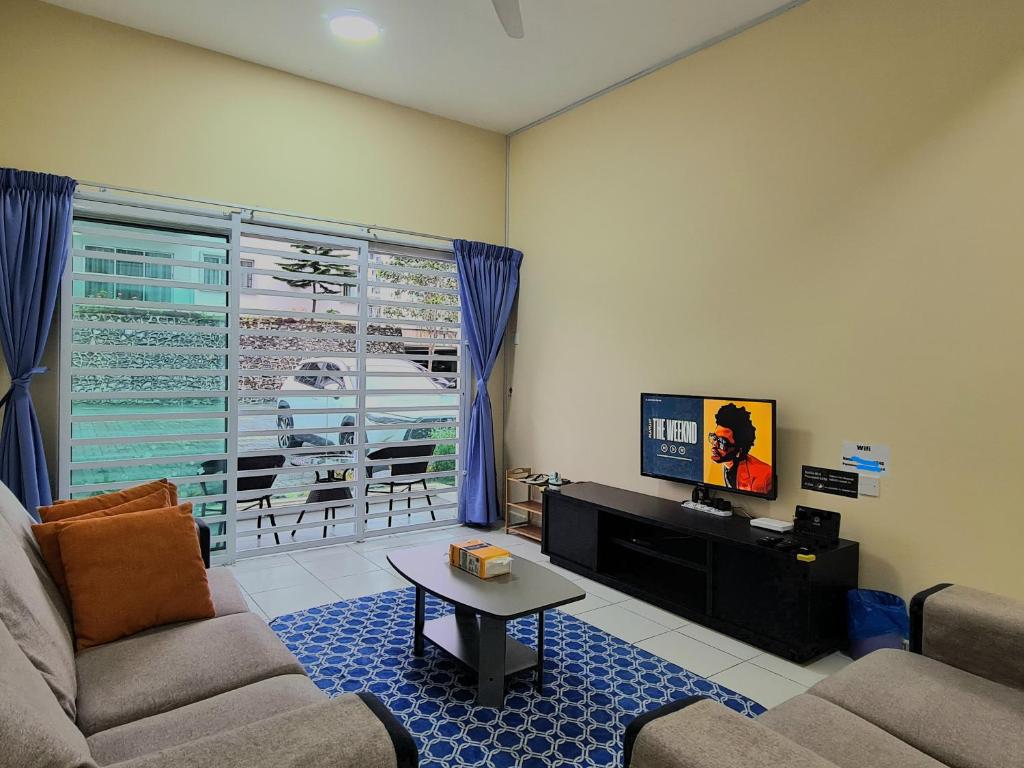 a living room with a couch and a tv at The Simplicity Homestay in Tanah Rata