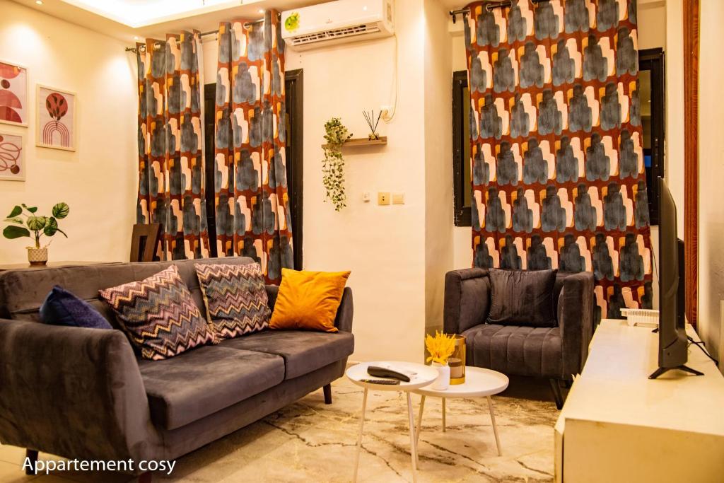 a living room with a couch and a chair at Studio cosy gold Douala Cameroon in Douala