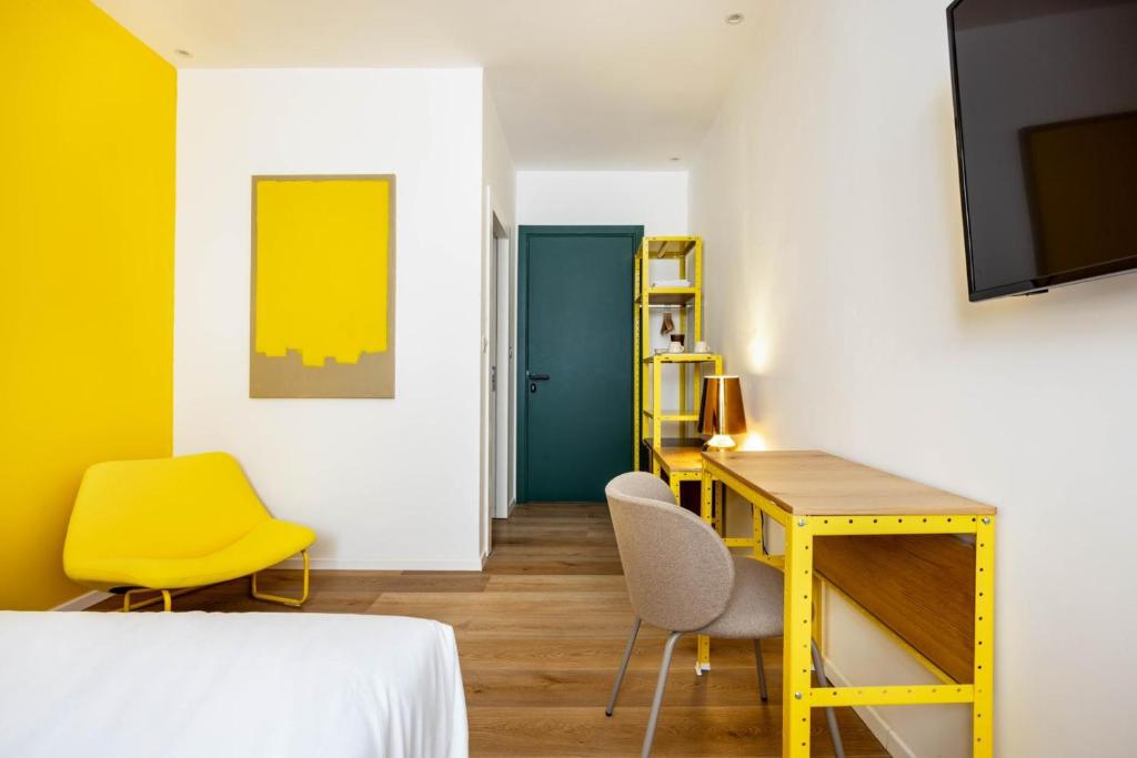 sypialnia z żółtym biurkiem i żółtym krzesłem w obiekcie Sirkin 16 Hotel - Autonomous hotel w mieście Giv‘atayim