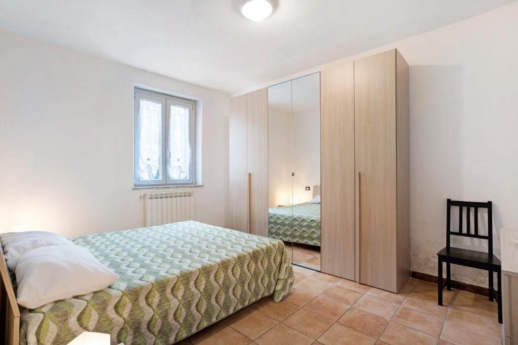 a bedroom with a bed and a window and a mirror at Casa Vacanze Il Torchio in Calice al Cornoviglio