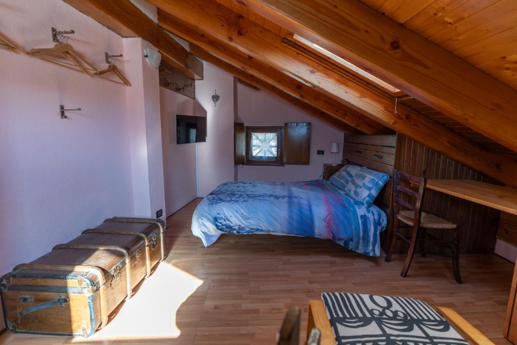 ein Schlafzimmer mit einem Bett und einem Schreibtisch im Dachgeschoss in der Unterkunft Excenex Apartment in Aosta