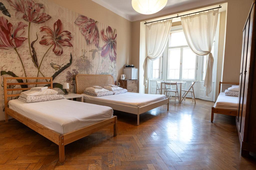a bedroom with two beds and a dining room with a table at Trzy Kafki Private Rooms in Krakow