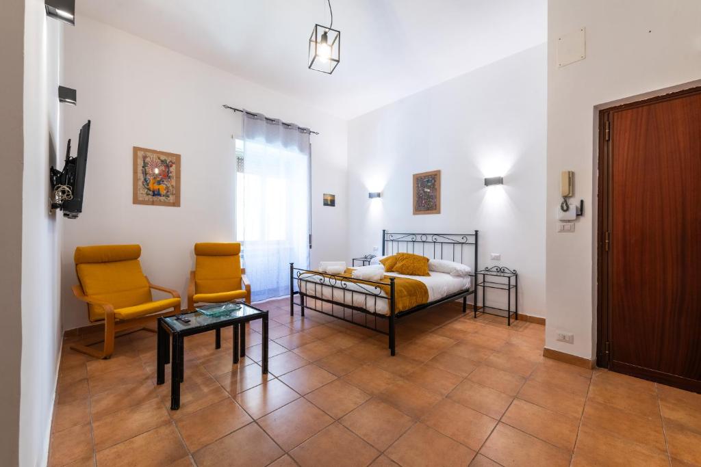 ローマにあるGianicolense Apartmentのベッドルーム1室(ベッド1台、椅子2脚、テーブル付)