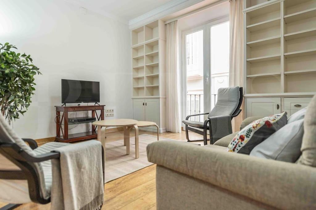 een woonkamer met een bank en stoelen en een tv bij Charming apartment with private patio by REMS in Málaga