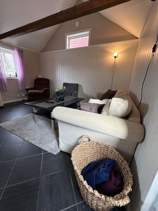 een woonkamer met een bank en een tafel bij Lite hus til leie sommeren 2024 in Arendal