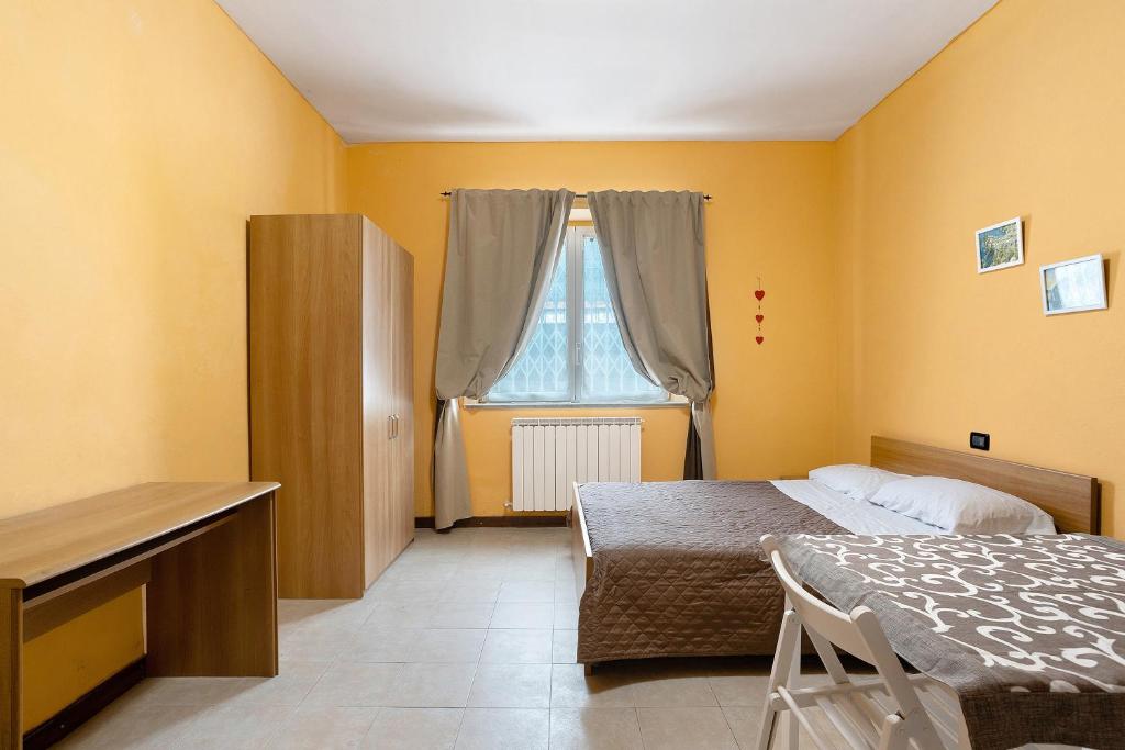 um quarto com uma cama, uma secretária e uma janela em Casa Vacanze Il Torchio Due em Pegui