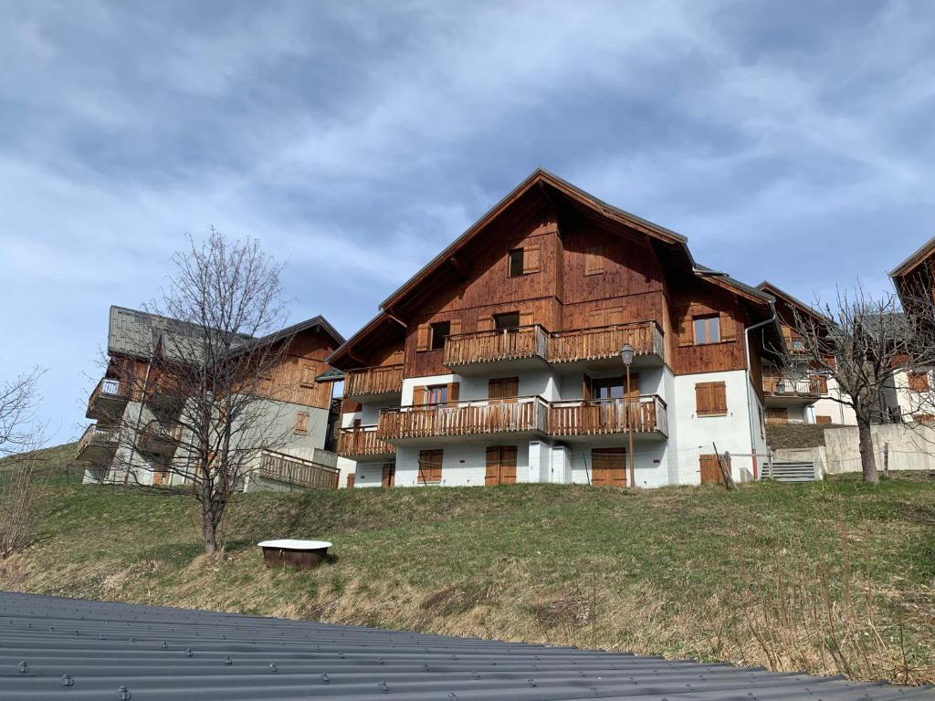 a large wooden building on top of a hill at Appartement dans Chalet 8 personnes in Albiez-Montrond