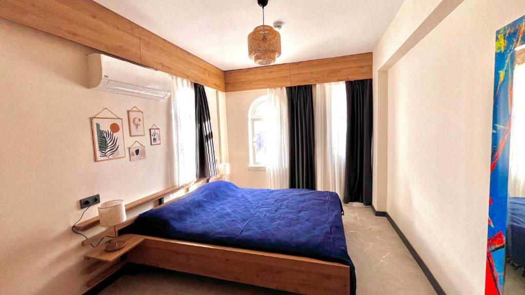 - une chambre avec un lit bleu et une fenêtre dans l'établissement Sencer Apart, à Marmaris