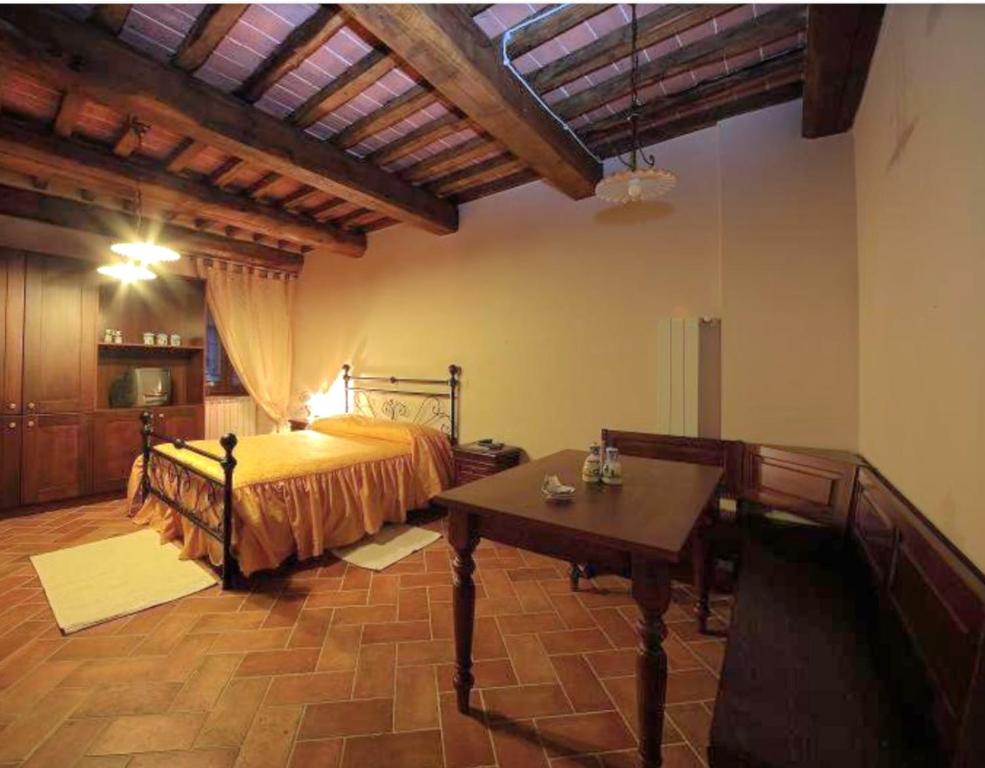a bedroom with a bed and a table in it at LA CASA DEL CALZOLAIO in Radicofani