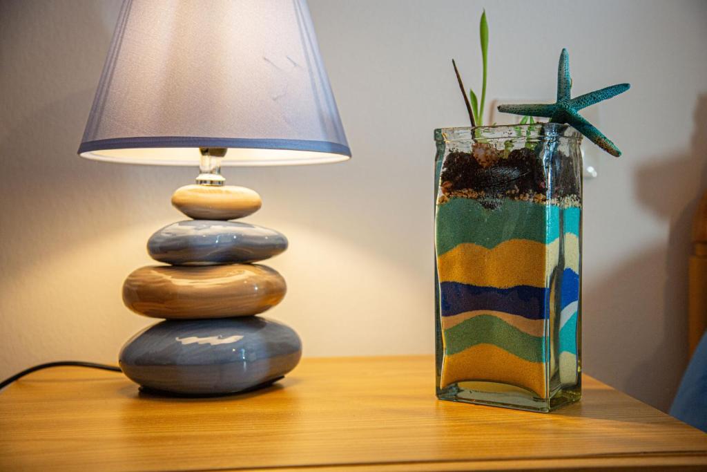 a lamp sitting on a table next to a vase at Appartamento IL LIMONE zona centrale vista mare in San Vincenzo
