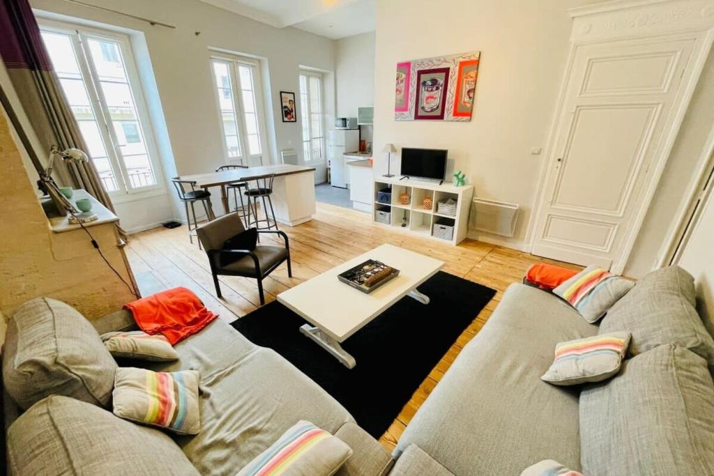 ein Wohnzimmer mit einem Sofa und einem Tisch in der Unterkunft Lafite furnished flat in Bordeaux