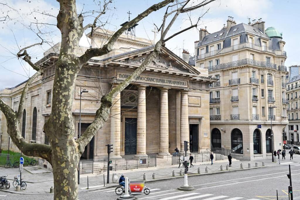un grand bâtiment situé dans une rue en face d'un bâtiment dans l'établissement Charme au Cœur de Paris, à Paris
