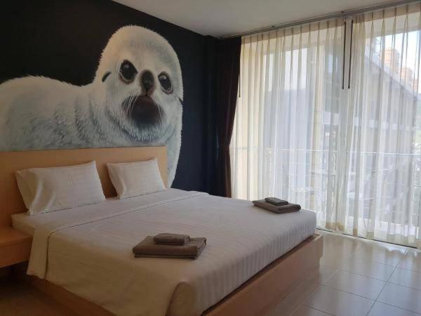 GO INN Aonang Beach โกอินน์ หาดอ่าวนาง في Ban Khlong Haeng: غرفة نوم بسرير مع لوحة على حيوان محشو