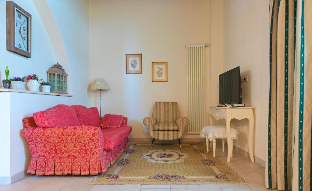 uma sala de estar com um sofá vermelho e uma cadeira em Greenery House em Empoli