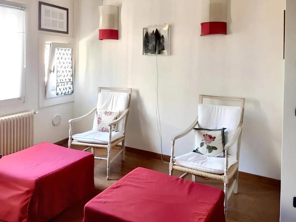 2 sillas y una mesa en una habitación con sábanas rojas en One bedroom apartement with city view and wifi at Venezia, en Venecia